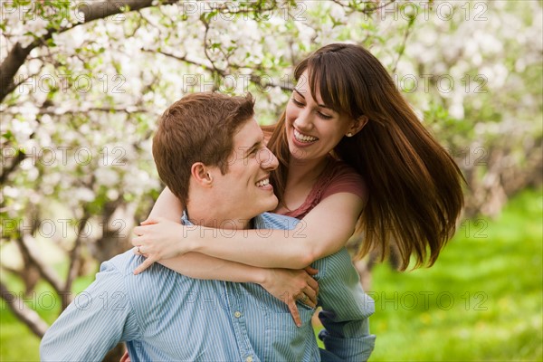 USA, Utah, Provo, Young couple embracing in orchard. Photo : Mike Kemp