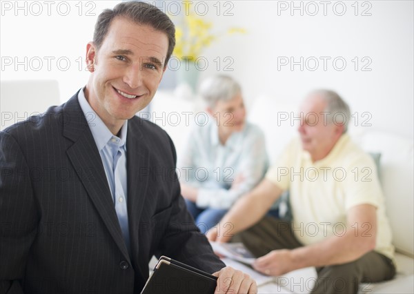 Portrait of businessman, senior couple in the background.