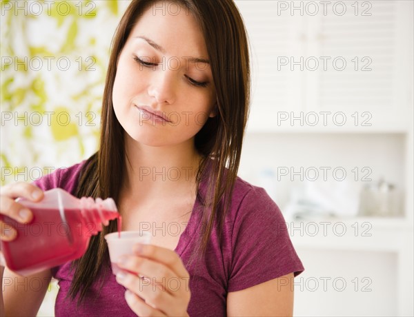 Young woman pouring syrup into measuring cup. Photo : Jamie Grill Photography