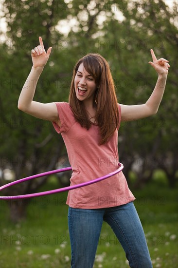 Young woman using plastic hoop in orchard. Photo : Mike Kemp