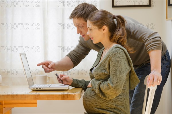 Couple using laptop at home. Photo : Rob Lewine