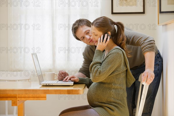 Couple using laptop at home. Photo : Rob Lewine