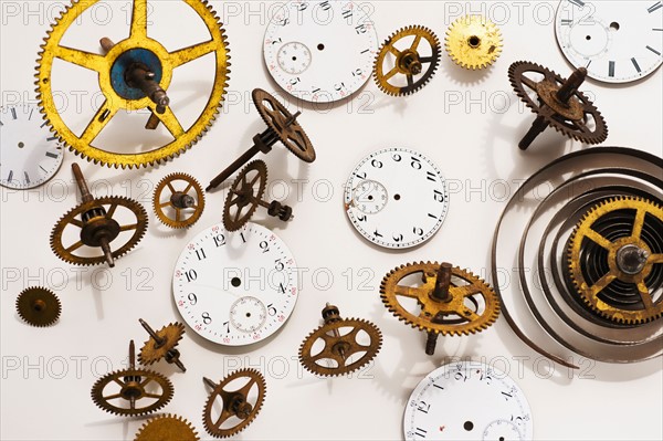 Close up of gears and clock parts on white background.