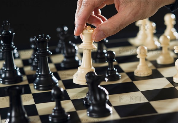 Close-up of man's hand playing chess.