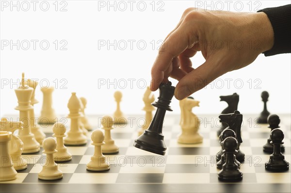 Close-up of man's hand playing chess.