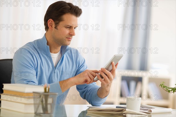 Man using digital tablet at home office.