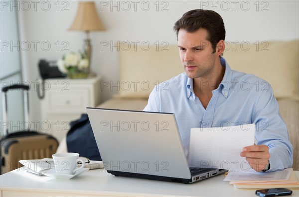 Man using laptop at home office.