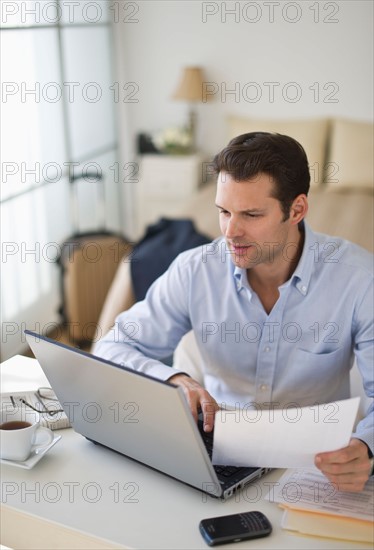 Man using laptop at home office.