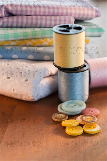 Close-up of thread, buttons and folded textiles.