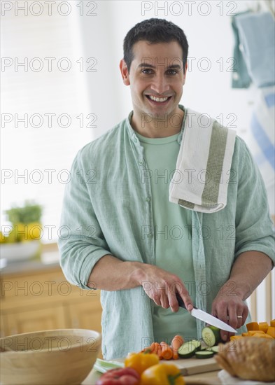 Mid adult man preparing vegetables in kitchen.