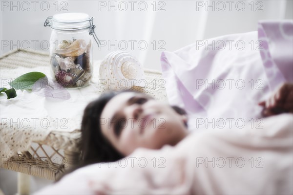 Young woman daydreaming in bed.