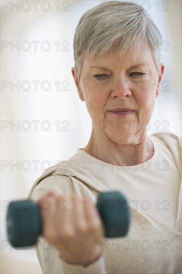 Senior woman lifting weights.