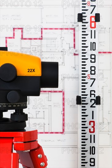 Close-up of theodolite, blueprint in the background.