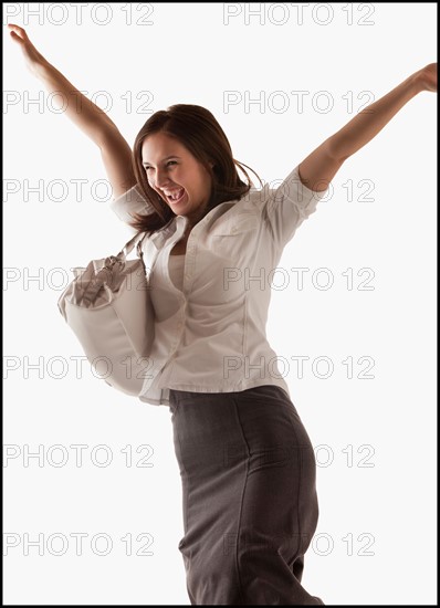 Studio shot of cheering woman. Photo : Mike Kemp