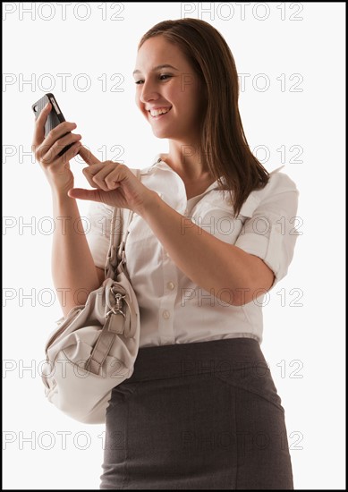 Studio shot of young woman with mobile phone. Photo : Mike Kemp