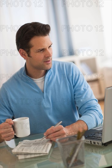 Man using laptop at home office.