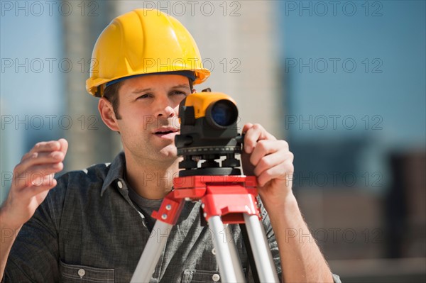 Surveyor using theodolite.