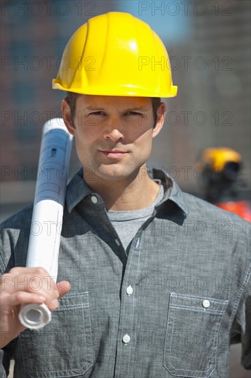 Portrait of worker holding blueprint.