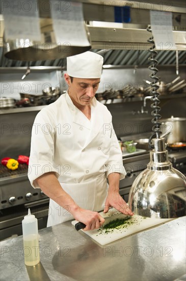 Chef preparing food in kitchen.