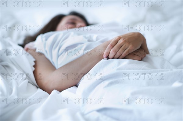 Young woman daydreaming in bed.