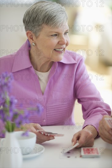 Senior woman playing cards.