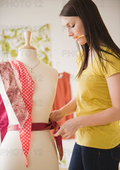Young woman working with dressmakers model. Photo : Jamie Grill Photography
