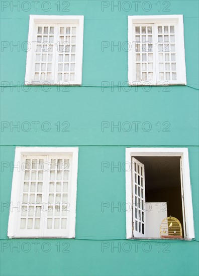 Brazil, Bahia, Salvador De Bahia, Facade of building with birdcage on open window. Photo : Jamie Grill Photography