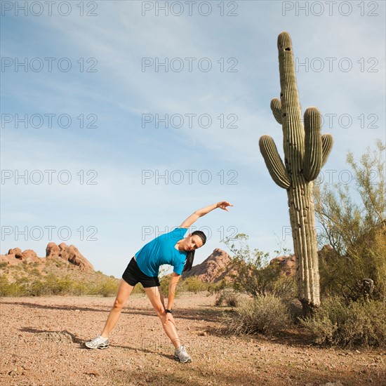 USA, Arizona, Phoenix, Young woman exercising on desert.