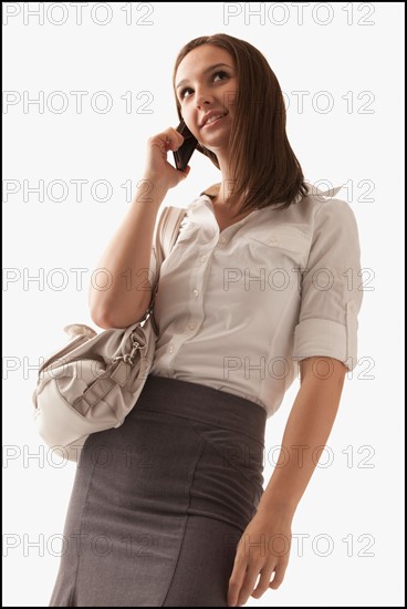 Studio shot of young woman with mobile phone. Photo : Mike Kemp