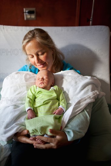 Mother with baby boy (0-1 months) on hospital bed. Photo : Noah Clayton