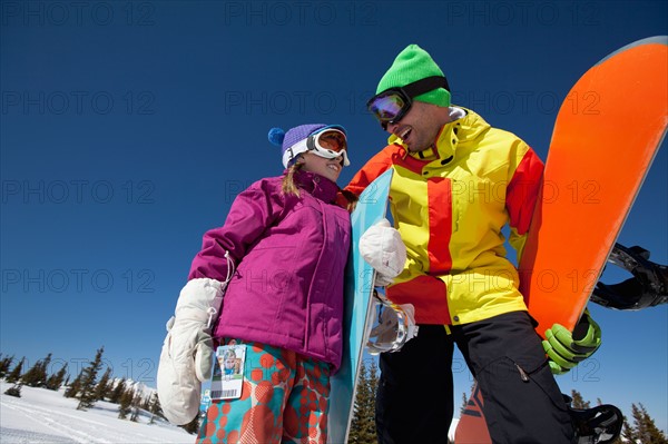 USA, Colorado, Telluride, Father and daughter (10-11) posing with snowboards in winter scenery. Photo : db2stock