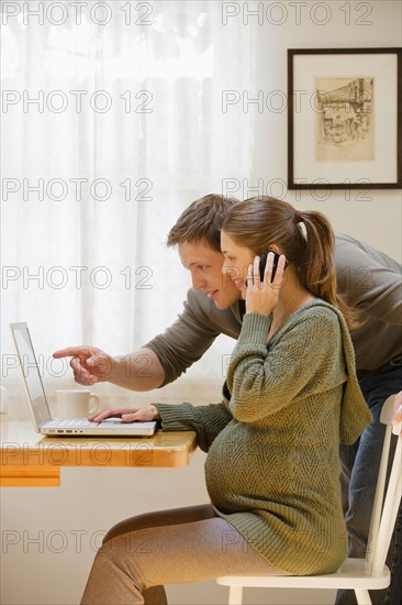 Couple using laptop at home. Photo : Rob Lewine