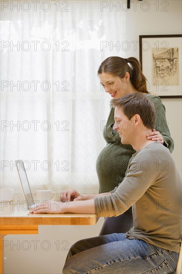 Couple using laptop at home. Photo : Rob Lewine