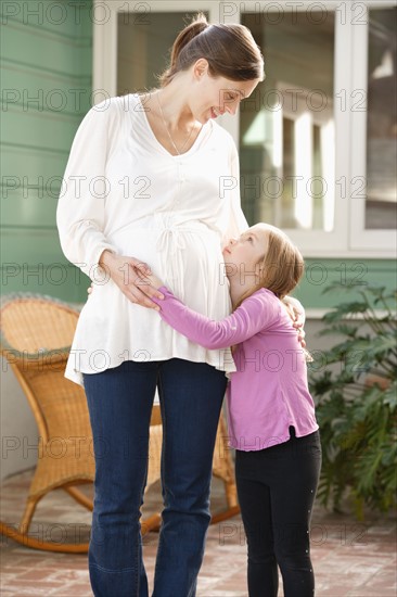 Expectant mother embracing daughter (4-5). Photo : Rob Lewine