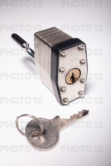 Close-up studio shot of silver padlock and key. Photo : Winslow Productions