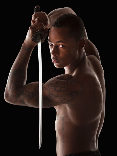 Studio shot of martial arts practitioner with Katana sword. Photo : Mike Kemp