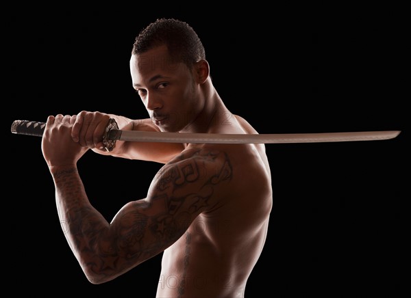 Studio shot of martial arts practitioner with Katana sword. Photo : Mike Kemp