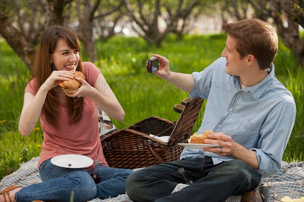 USA, Utah, Provo, Young couple having picnic in orchard. Photo : Mike Kemp