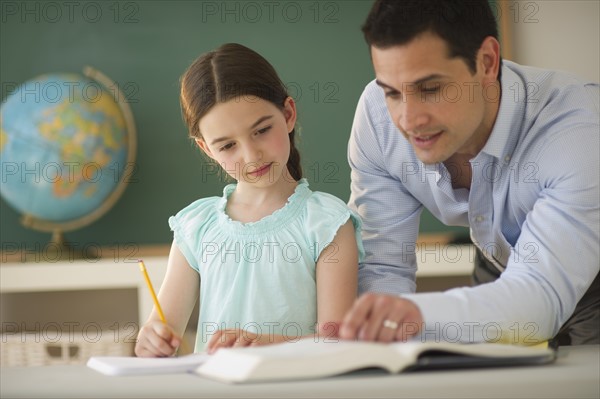 Teacher helping schoolgirl (8-9).