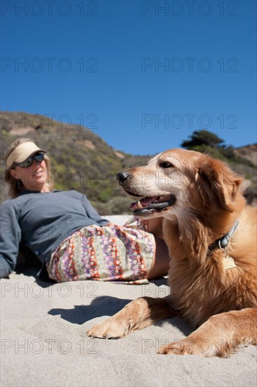 Golden retriever with owner on beach. Photo : Noah Clayton