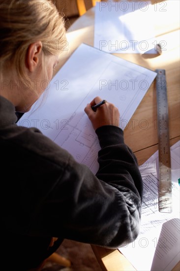 Female architect drawing plans. Photo : Noah Clayton