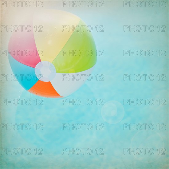 Close up of striped beach ball against water surface. Photo : Jamie Grill Photography