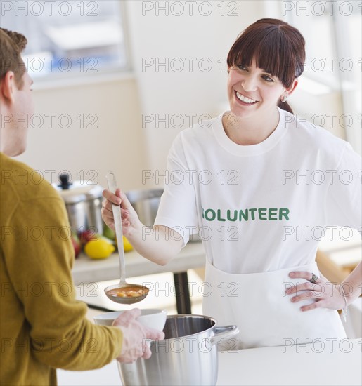 Charity volunteer handing out free soup. Photo : Daniel Grill