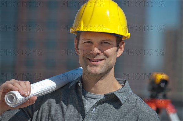 Portrait of worker holding blueprint.