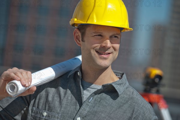 Portrait of worker holding blueprint.