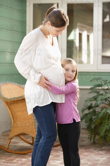 Expectant mother embracing daughter (4-5). Photo : Rob Lewine