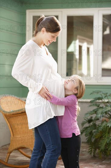 Expectant mother embracing daughter (4-5). Photo : Rob Lewine