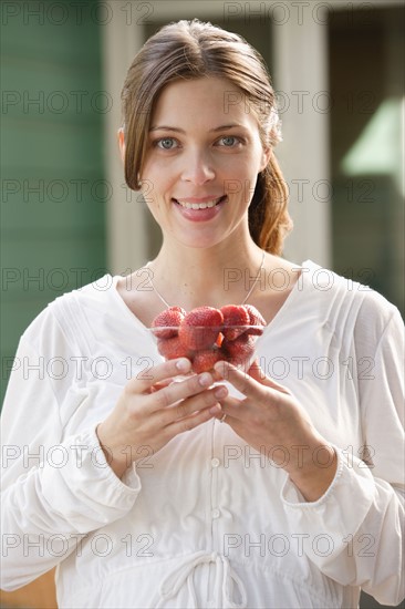 Portrait of expecting mother eating strawberries. Photo : Rob Lewine