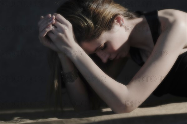 Woman with hands clasped, relaxing.