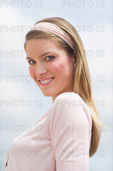 Portrait of young woman smiling outdoors.